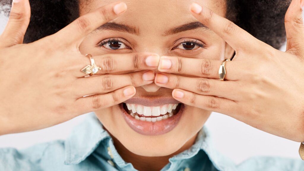 A girl is smiling and trying to debunk the teeth whitening myths